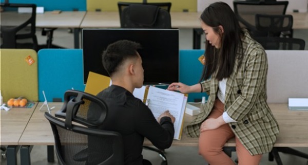2 students at a computer discussing a subject